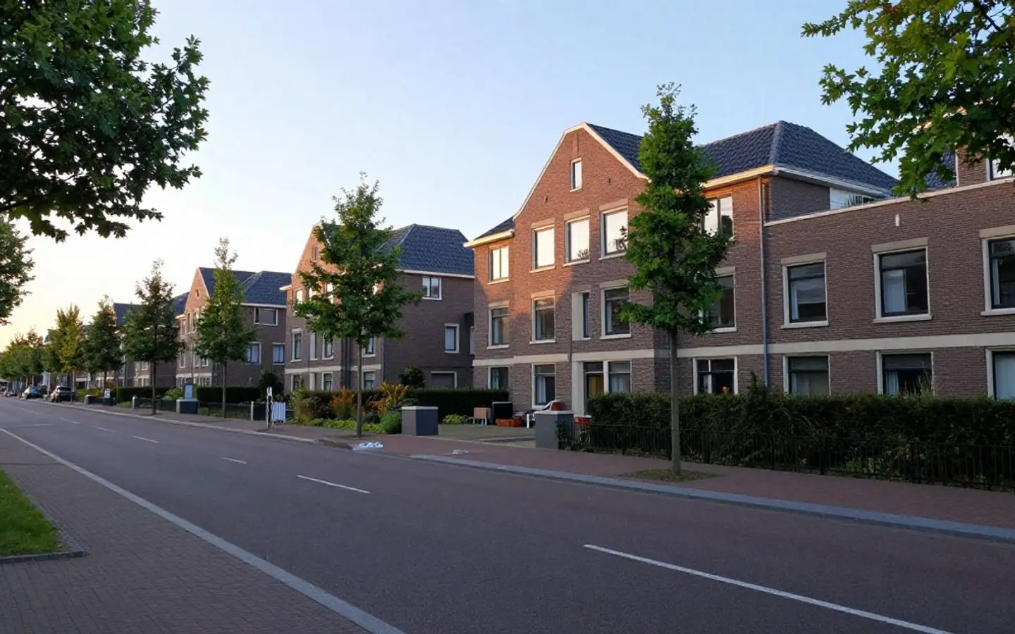 Lange Nederlandse woonstraat met rijwoningen aan weerszijden
